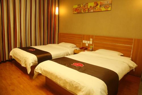 Fengxin尚客优连锁江西宜春奉新冯川东路黄泥巷店的一间酒店客房,房间内设有两张床