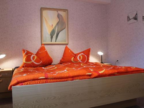 克吕茨Peaceful Apartment in Klutz Germany near Boltenhagener Beach的一间卧室配有一张带橙色棉被的床