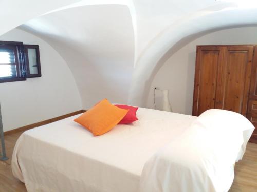 科尔萨诺Casa salento的卧室配有白色床和橙色枕头
