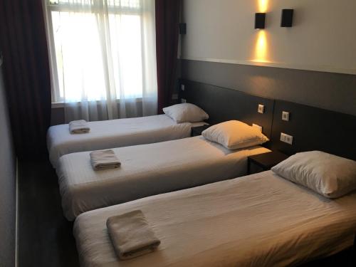 阿姆斯特丹莫纳法酒店的酒店客房,配有三张床和毛巾