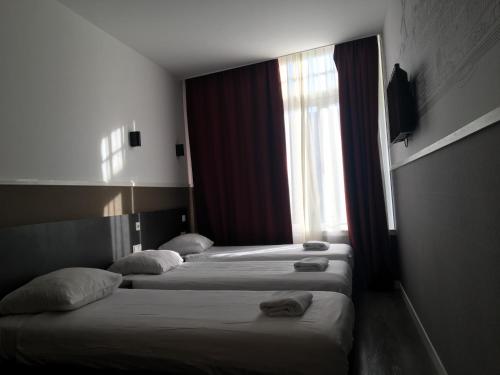 阿姆斯特丹莫纳法酒店的带窗户的酒店客房内的三张床