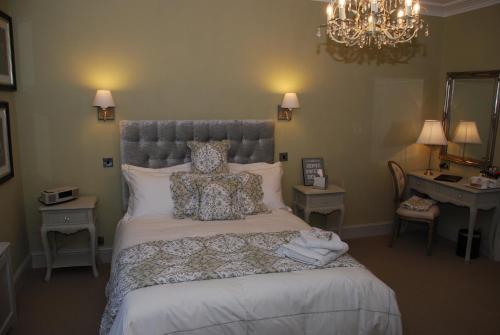 哈罗盖特斯普林代尔旅馆的一间卧室配有一张带枕头的床和吊灯。