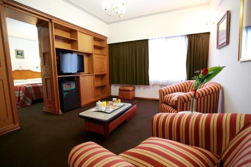 圣达菲Hotel Riogrande - Habilitado的酒店客房设有两把椅子、一张桌子和电视。
