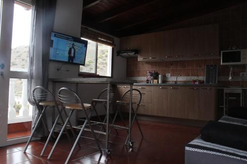 巴列埃尔莫索Casa La Hagar的厨房设有带凳子的酒吧和一台电视