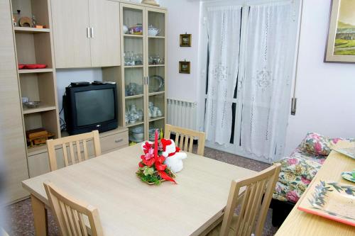 萨沃纳Relax e mare的一间带桌子和电视的用餐室