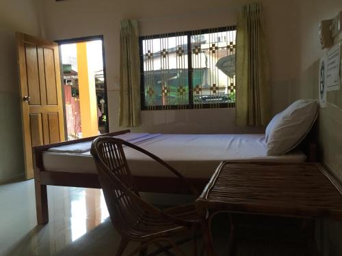 贡布Ta Eng Guesthouse的卧室配有床、椅子和窗户。