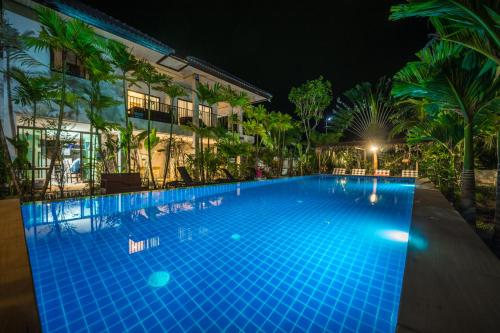 功孟海滩浓瑟勒山景旅馆的一座游泳池,在晚上在建筑物前