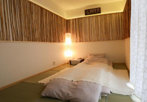 横滨Lucy's House横浜中華街 House2的卧室配有一张挂有墙上标志的床