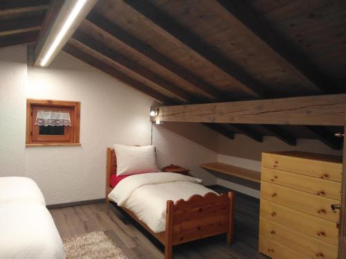 利维尼奥Baita Rini的阁楼卧室设有1张床和1间阁楼