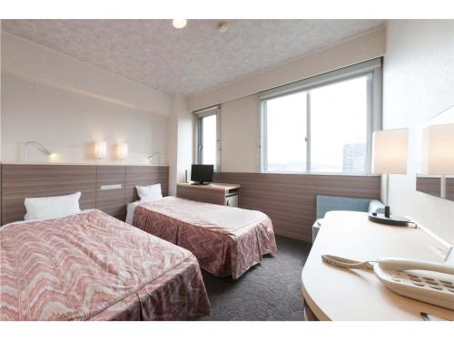 尾道市尾道第一酒店的酒店客房配有两张床和一张书桌