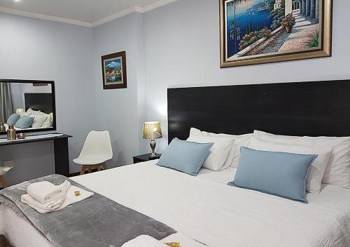 克莱克斯多普Gemstone Guest House的卧室配有带蓝色枕头的大型白色床