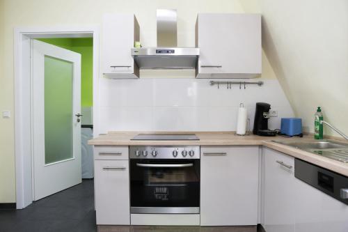 多森海姆海德堡夏洛特度假屋的厨房配有白色橱柜和炉灶。