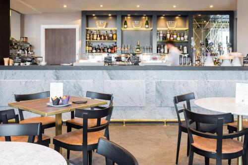 奥本The Perle Oban Hotel & Spa的一间带桌椅的餐厅和一间酒吧