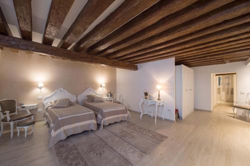 威尼斯萨伏伊约兰达公寓的一间卧室设有两张床和木制天花板