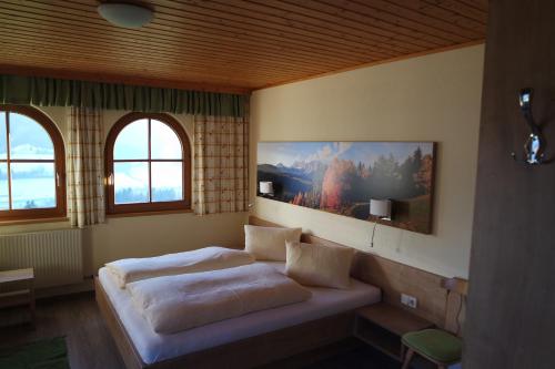 恩斯塔尔豪斯Gästehaus Davidbauer的一间卧室设有一张床和两个窗户。