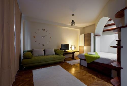 布达佩斯Green Apartment的卧室配有沙发和墙上的时钟