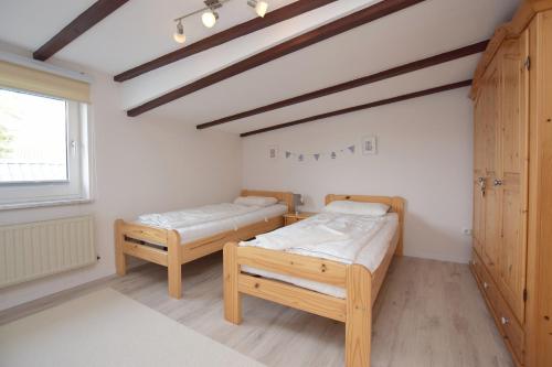 格吕克斯堡Ferienwohnung Ostseelys的客房设有两张床和窗户。