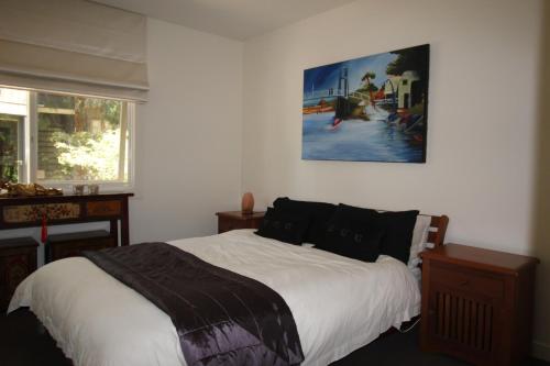 洛恩洛恩度假屋的卧室配有一张床,墙上挂有绘画作品