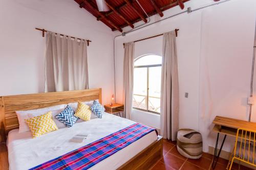 南圣胡安Selina Maderas的一间卧室配有一张带色彩缤纷枕头的床和窗户。
