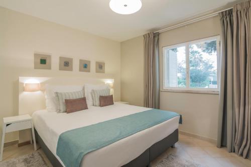 金塔湖Apartamentos Valverde - Quinta do Lago的一间卧室设有一张大床和一个窗户。