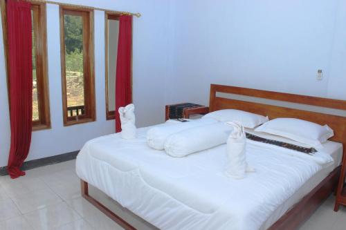 纳闽巴霍丹克旅馆 的一间卧室配有带白色床单和枕头的床。