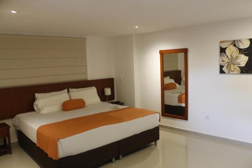 巴兰卡韦梅哈Hotel Bachue的一间卧室配有一张大床和镜子