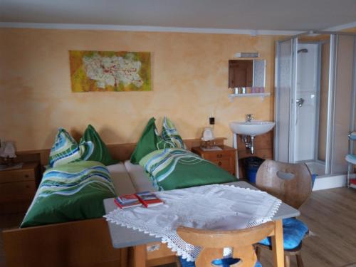 约赫贝格Talhof的客厅配有沙发和带绿色枕头的桌子