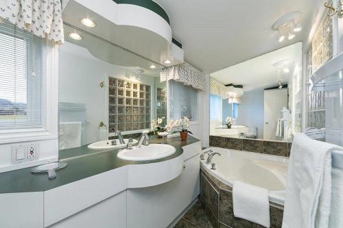拜圣保罗271 - La Victorienne - Les Immeubles Charlevoix的白色的浴室设有2个盥洗盆和1个浴缸。