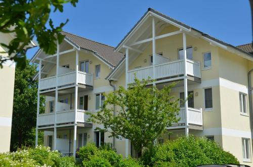宾茨Wohnpark Stadt Hamburg - Apt. 04的公寓大楼设有阳台和树木