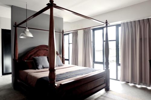 清迈古色古香清迈酒店的一间卧室设有一张天蓬床和大窗户