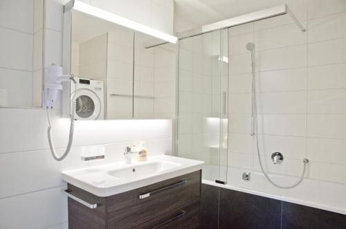 因特拉肯Apartment Anemone - GriwaRent AG的白色的浴室设有水槽和淋浴。