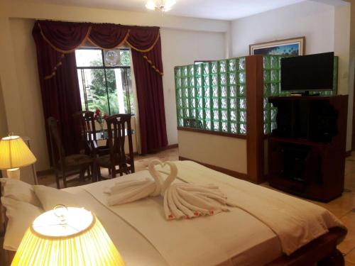 伊基托斯Amazon Green Hotel的一间卧室配有一张床,床上有毛巾