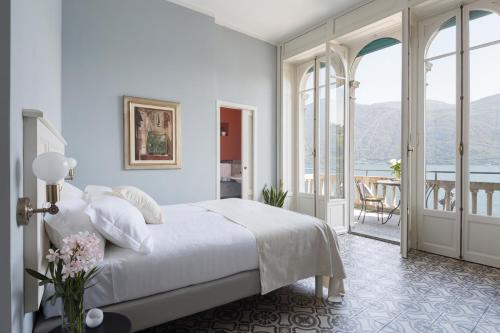坎诺比奥Villa Maria Hotel的一间白色卧室,配有床和阳台