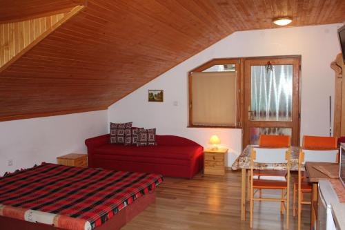 维内Apartmany u Janka Vinné Jazero的客厅配有红色的床和桌子