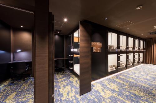 东京秋叶原格兰斯特胶囊旅馆的更衣室设有黑色墙壁和蓝色地毯