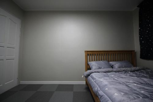 春川森林度假屋的一间卧室配有一张带蓝色枕头的床。