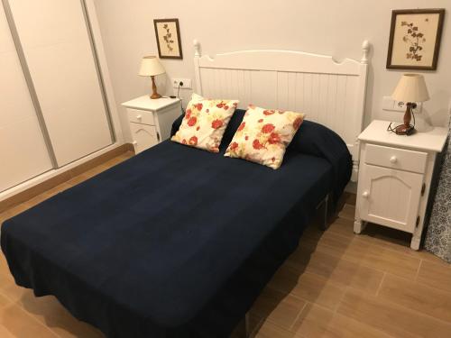 桑卢卡尔-德巴拉梅达Infantes 8-4-30的一间卧室配有一张带蓝色床单的床和2个床头柜。