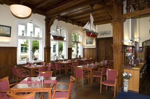 维斯马维斯马餐厅及酒店的餐厅设有木桌、椅子和窗户。