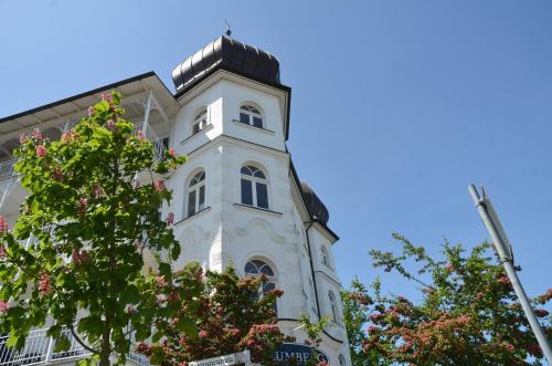 宾茨Haus Metropol - Fewo 7 mit Balkon und Meerblick的一座高大的白色建筑,有钟楼