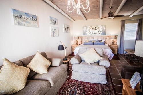 雅可布湾Fijnbosch@Jacobsbay的一间卧室配有一张床和两张沙发