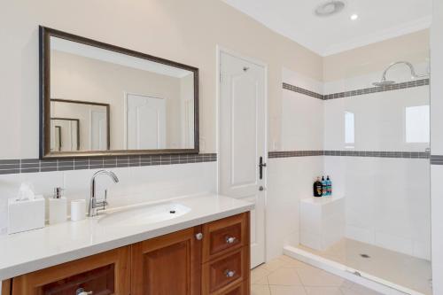 珀斯索伦托海滩住宿加早餐酒店的一间带水槽、镜子和淋浴的浴室