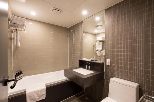 釜山贝豪德酒店的带浴缸、盥洗盆和卫生间的浴室
