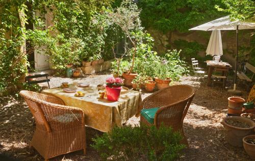 阿尔勒维哥波恩德B&B酒店的花园里种有植物,配有桌椅