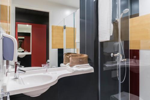 亚贝克ibis budget Brugge Jabbeke的一间带水槽和玻璃淋浴的浴室