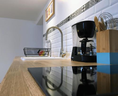 Couffyla maisonette Arelo的厨房柜台配有水槽和咖啡壶