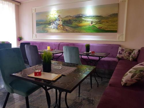 波热加Bed & Breakfast Vila Stanišić的用餐室配有紫色的沙发、桌子和椅子