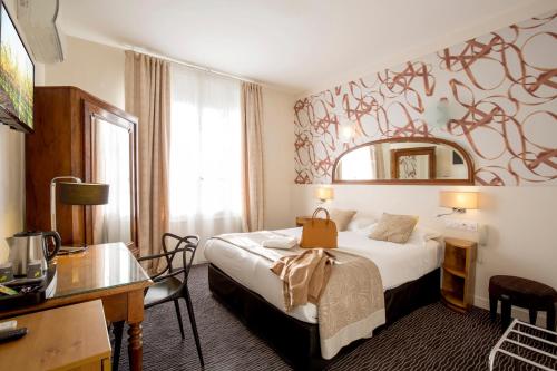 图卢兹雷蒙德4号图卢兹酒店的配有一张床和一张书桌的酒店客房