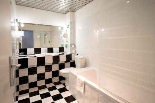 图卢兹雷蒙德4号图卢兹酒店的浴室铺有黑白格子地板。