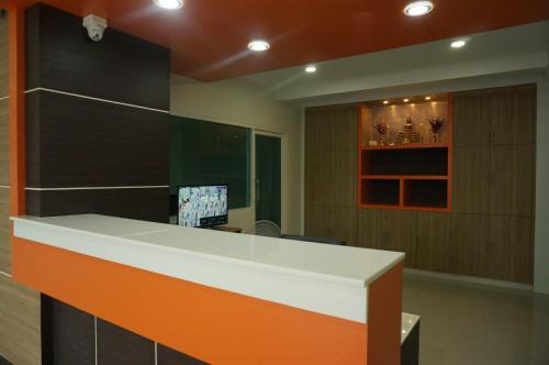 华欣AD住宿公寓的办公室设有橙色和白色的前台