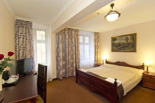 托伦利特曼酒店的一间卧室配有一张床和一台电视